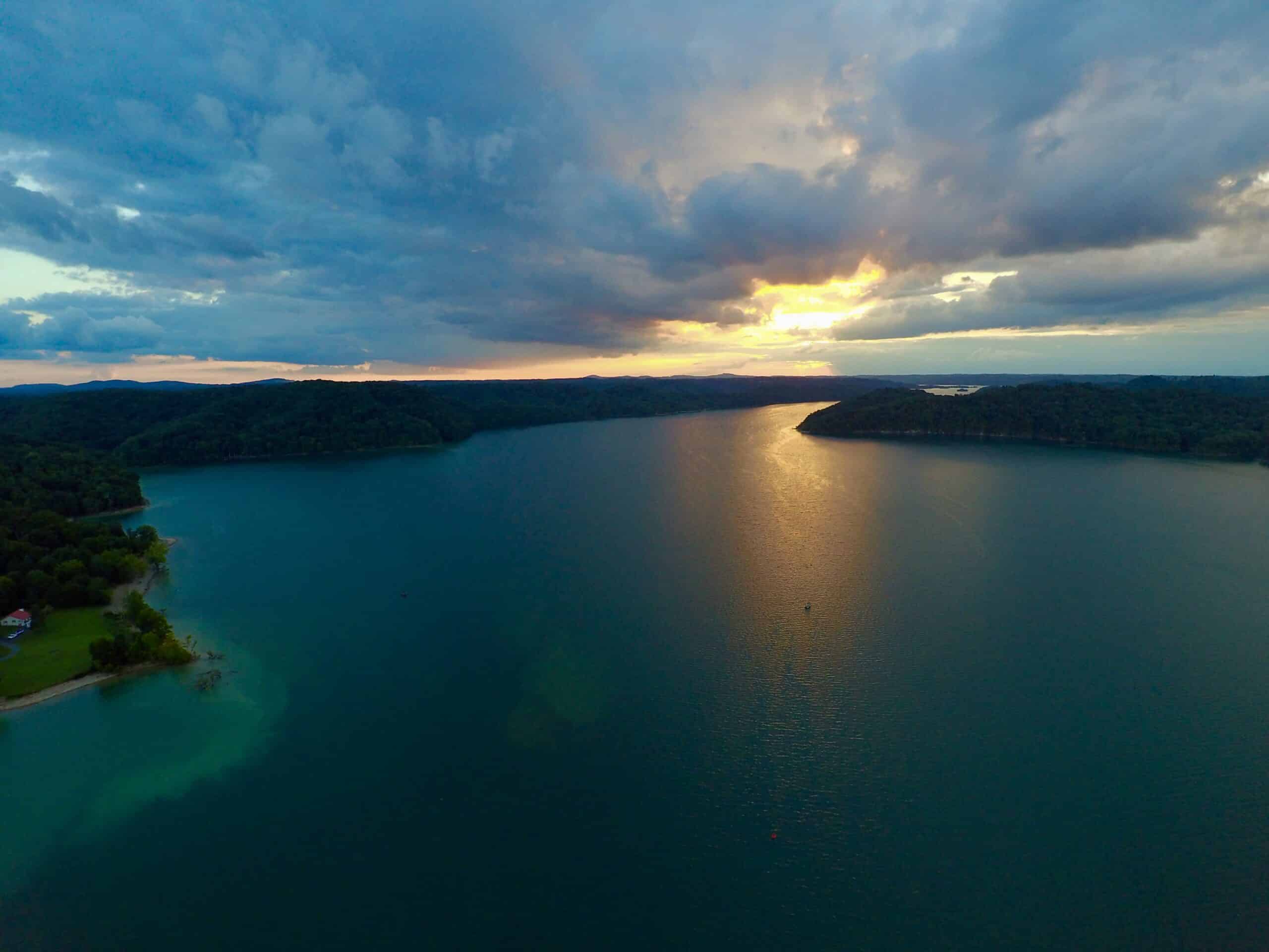 drone view of the calm lake at sunset with blue clouds above