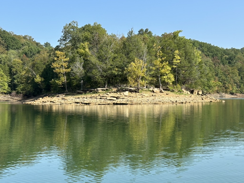 Calm water and a beach on Dale Hollow Lake that contains crinoids.