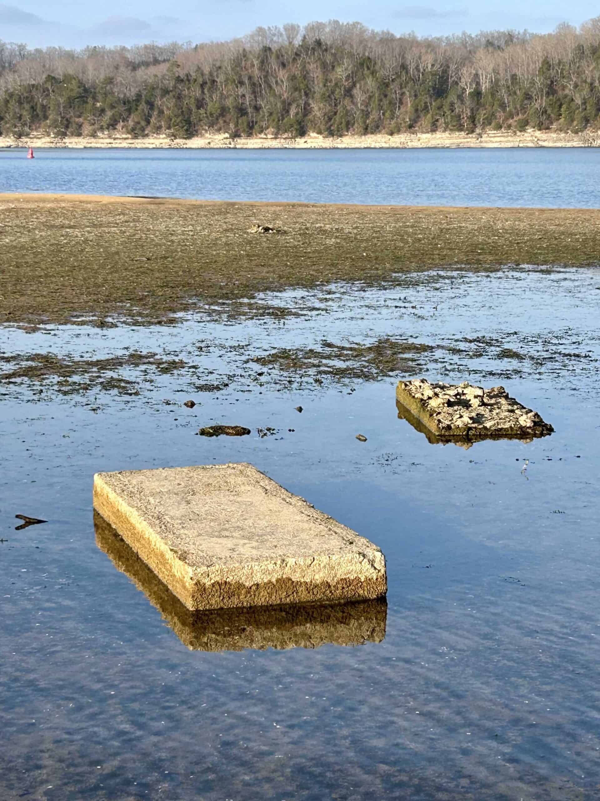 Calm water around two old underwater grave vault slabs