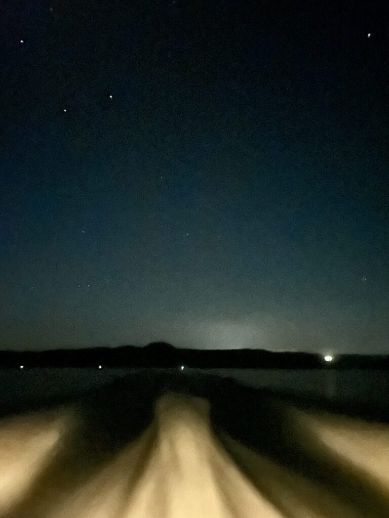 Boat wake at night time with a sky of stars.